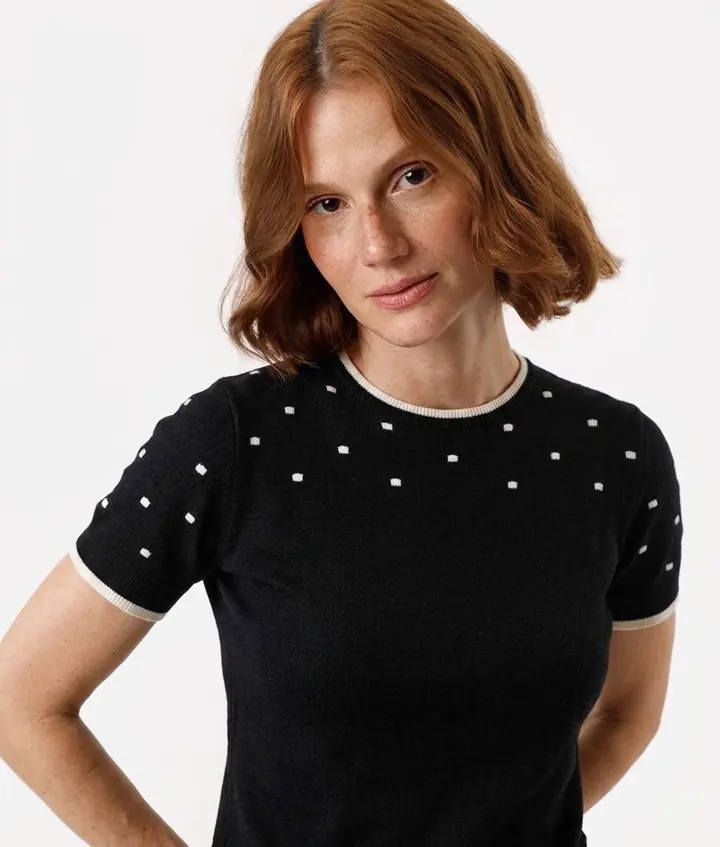 Blusa preta de tricô, manga curta, com poá quadrado creme e gola e punhos canelados em creme.